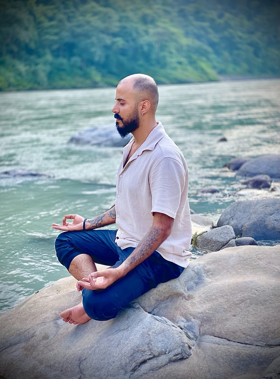 Atul Verma seated in meditation beside the river